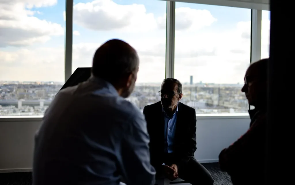 Beberapa orang pebisnis sedang berdiskusi secara informal sebelum sebuah rapat besar.