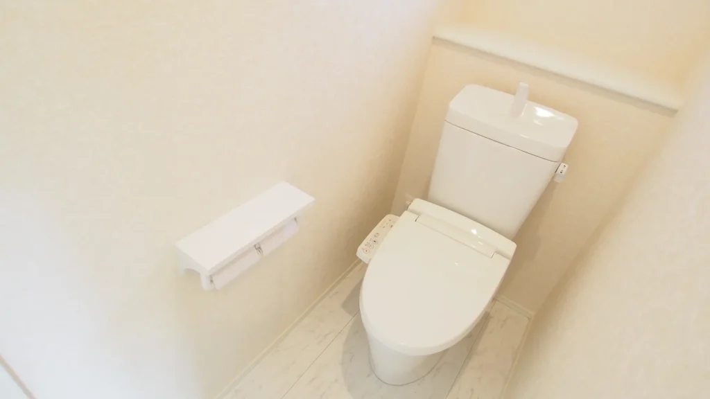 Orang-orang sedang menunggu antrean di depan sebuah toilet umum yang bersih.