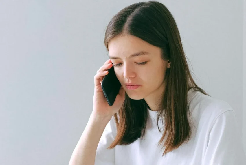 Seorang operator layanan darurat sedang berbicara di telepon dengan headset.