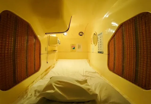 Interior sebuah hotel kapsul dengan deretan pod tidur yang modern.