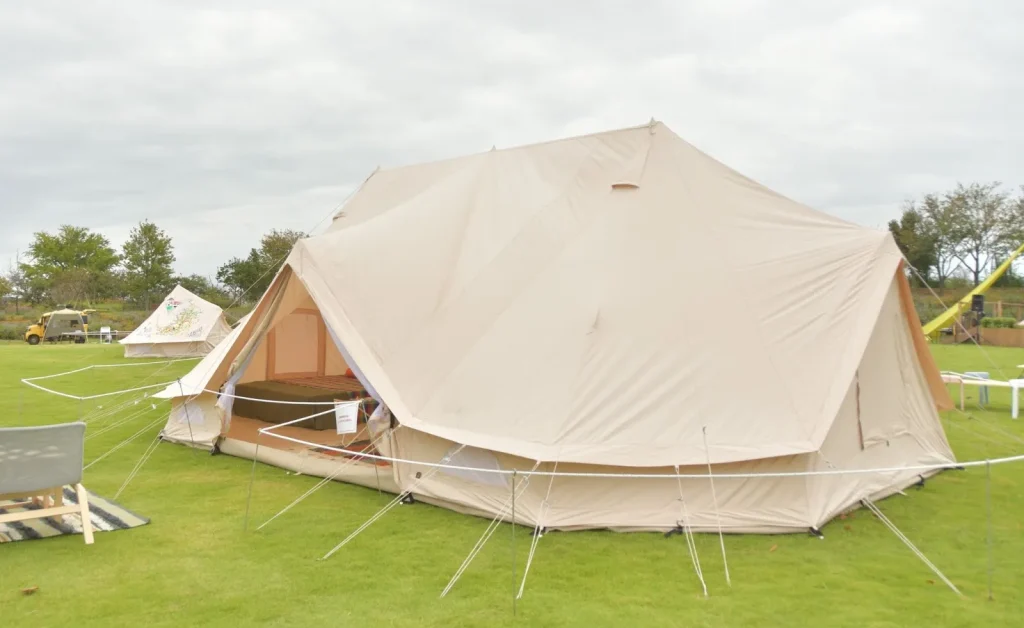 Sebuah tenda glamping mewah yang didirikan di tengah hutan.