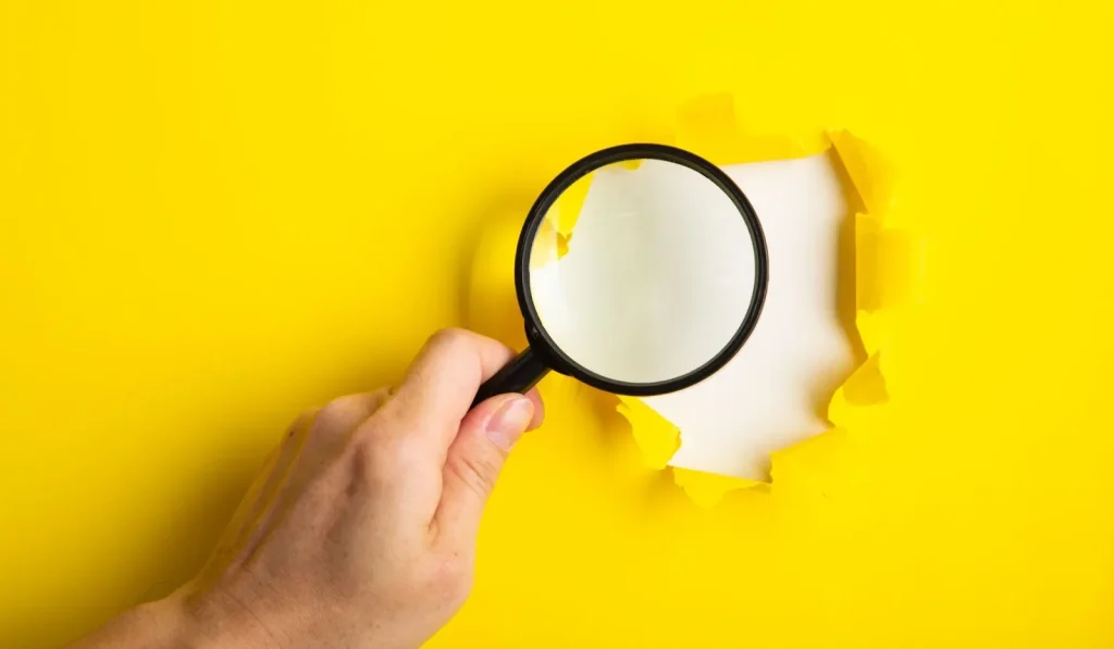 Seseorang sedang mencari lowongan kerja di laptop dengan secangkir kopi.