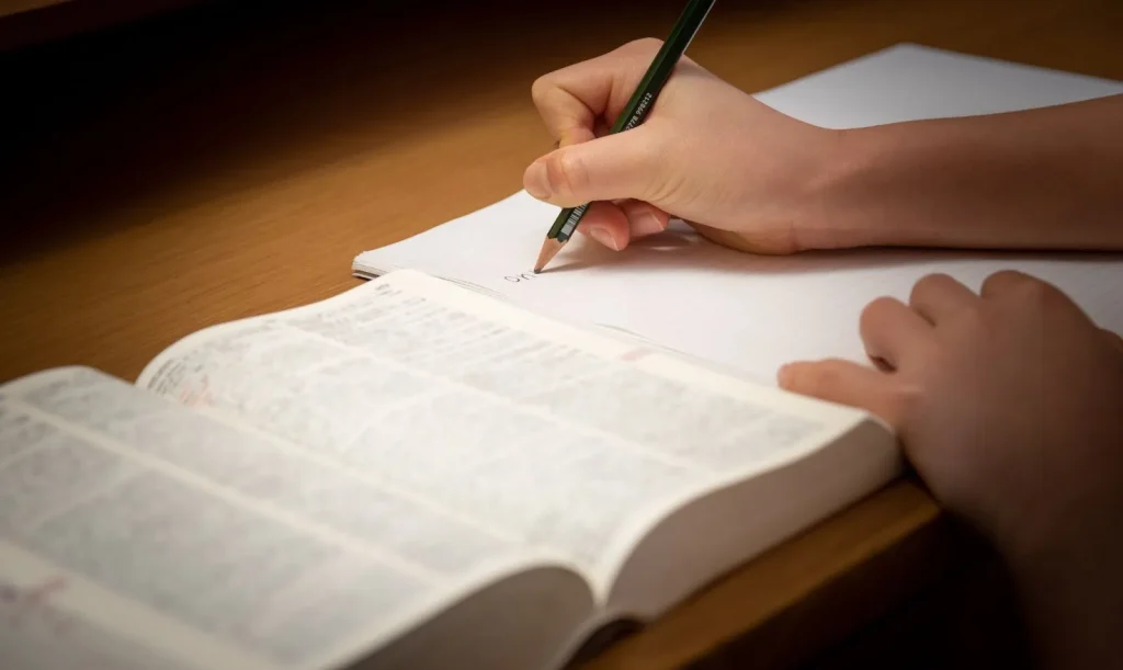 Seseorang sedang mengerjakan ujian di depan komputer.