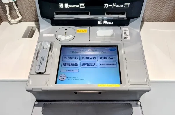 Layar mesin ATM Jepang dengan berbagai menu dalam bahasa Jepang.