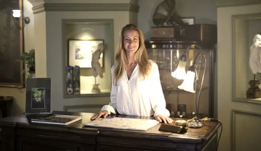 Seorang staf restoran sedang menyapa tamu.