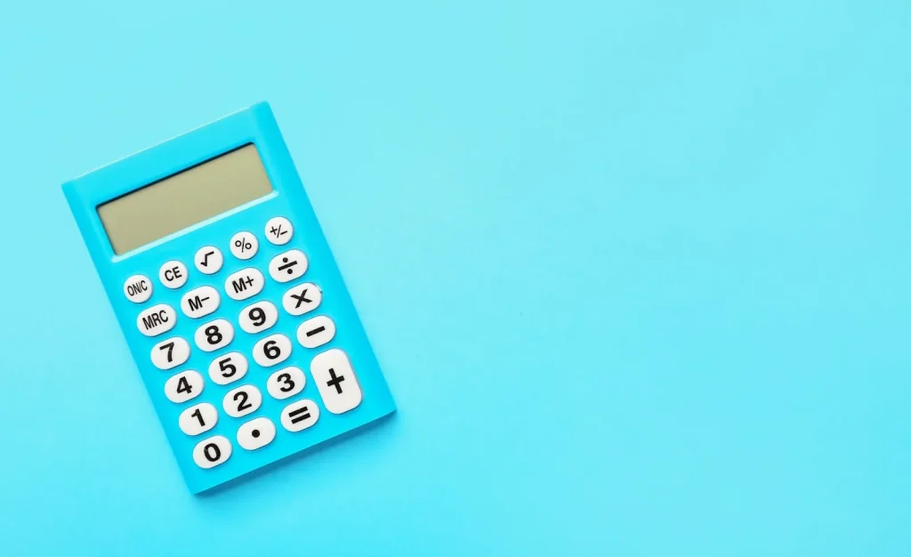 Seseorang sedang menghitung pajak menggunakan kalkulator.