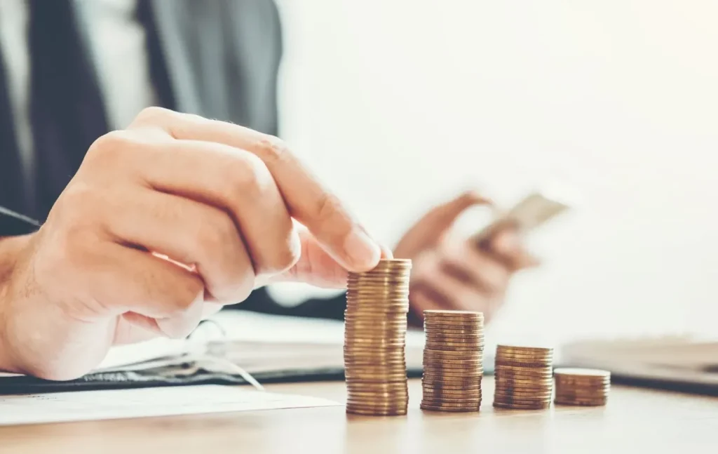 Seseorang sedang melakukan penghematan dengan memasukkan uang ke celengan.