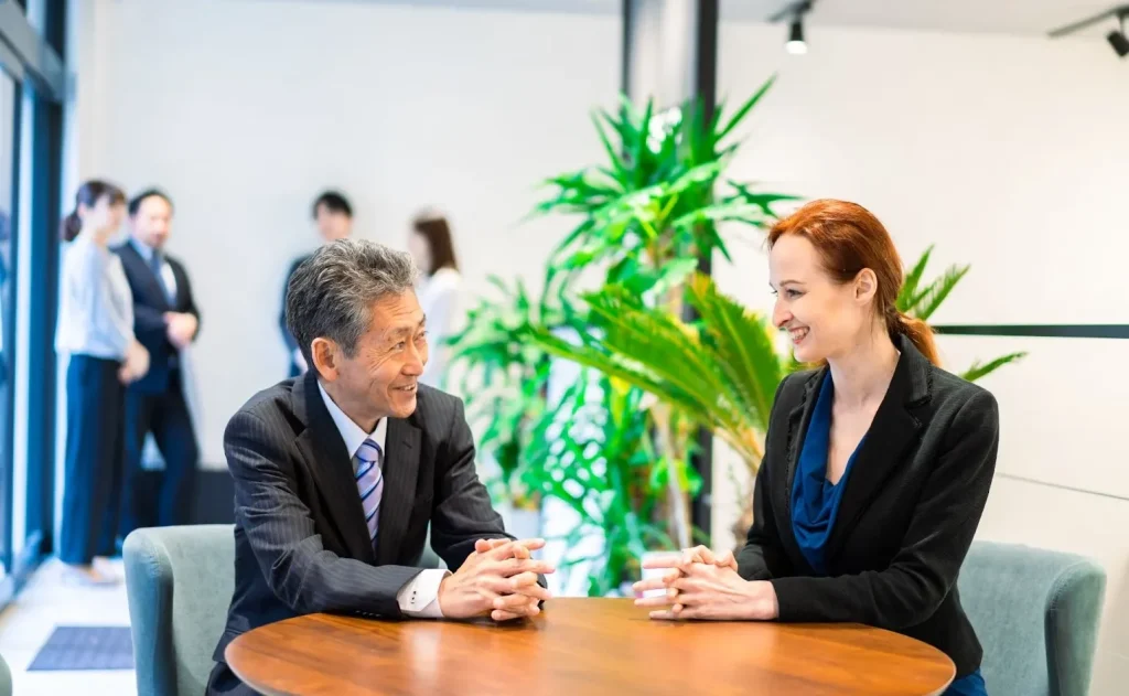 Dua kelompok profesional dari budaya yang berbeda sedang berjabat tangan.