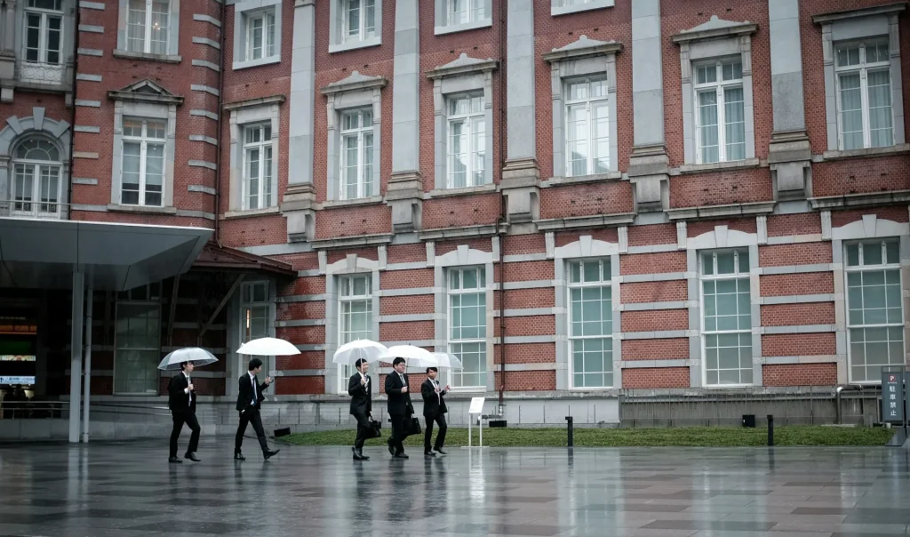 Seorang profesional sedang bekerja di depan laptop di sebuah kantor modern.