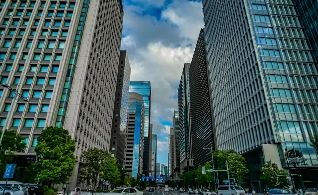 Seorang profesional sedang melihat cakrawala kota dari jendela kantor.
