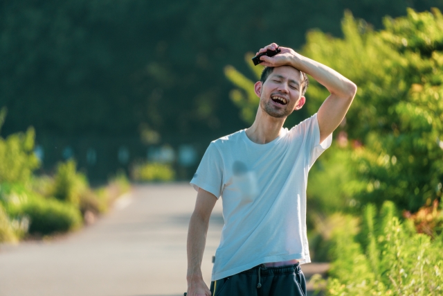Seorang mahasiswa tersenyum sambil memegang buku