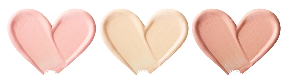 Seorang wanita sedang tersenyum sambil memegang produk makeup.