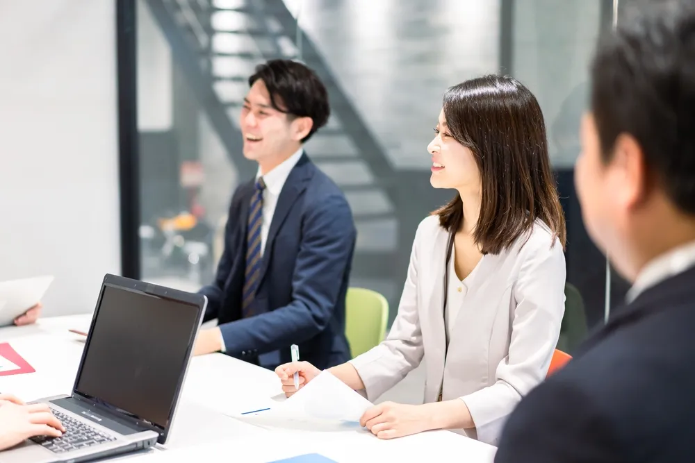 Beberapa orang pebisnis sedang rapat dan melihat sebuah draf dokumen.