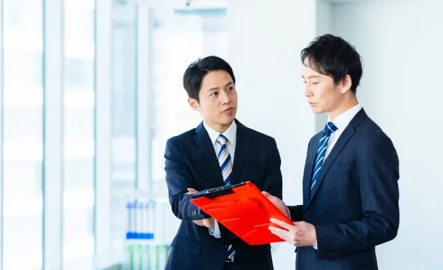 Seorang pebisnis sedang berbicara dengan sopan kepada atasannya.