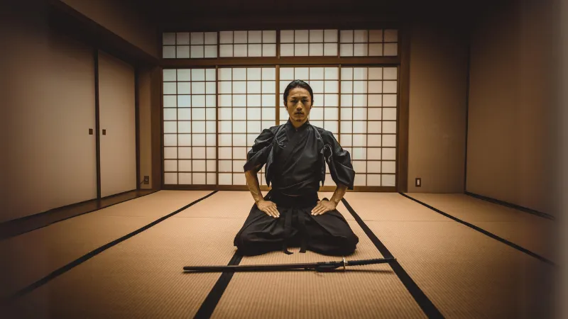 Lukisan kuno yang menggambarkan seorang samurai sedang membungkuk.